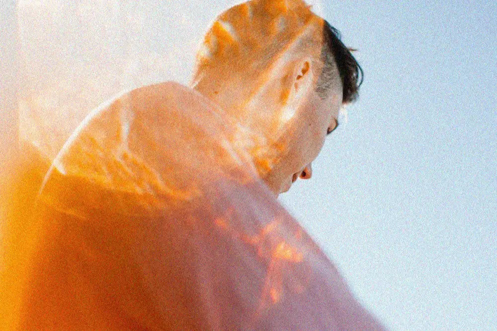 Person with a glowing orange light against a light blue sky